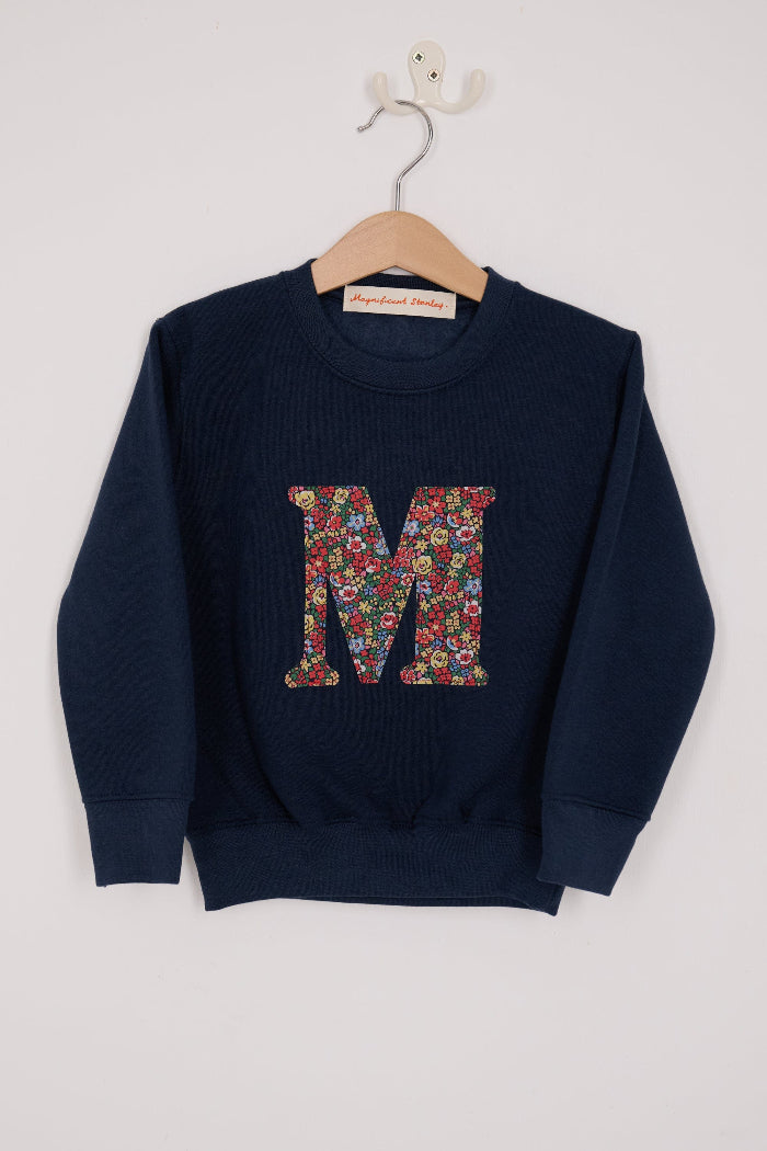 A navy Magnificent Stanley personalised Navy Sweatshirt with her initial on the front in floral emma louise liberty print.