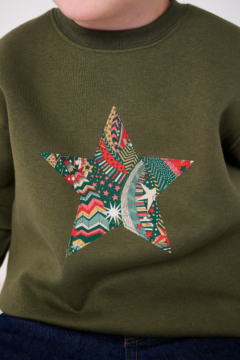 a 5 year old wearing a Magnificent Stanley Khaki Christmas Jumper Sweatshirt with a star on the front made from Liberty Print fabric.