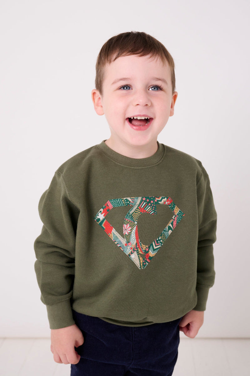 a happy kid in a Magnificent Stanley sweatshirt Superhero  initial Khaki Sweatshirt in My Little Star Liberty fabric