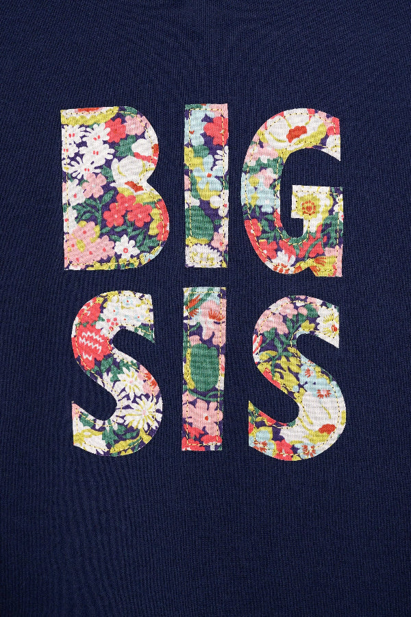 A close up of a navy cotton t-shirt with BIG SIS in floral letters on the front. the letters are cut from Liberty print and appliquéd on.