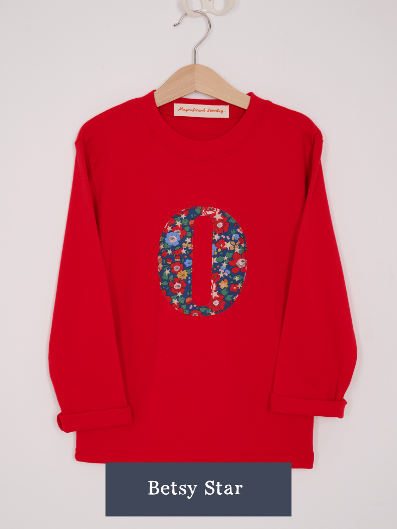 a Magnificent Stanley long sleeve Red birthday T-Shirt with an initial on the front in Betsy star Liberty Print