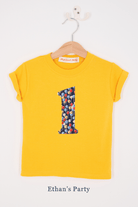 a yellow birthday t-shirt with a number 1 cut from ethan's party balloon liberty floral print on the front.