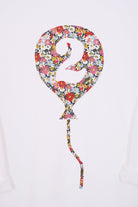 A close up of a 2nd birthday white t-shirt with a balloon and number 2 on it made from Liberty Floral print fabric.