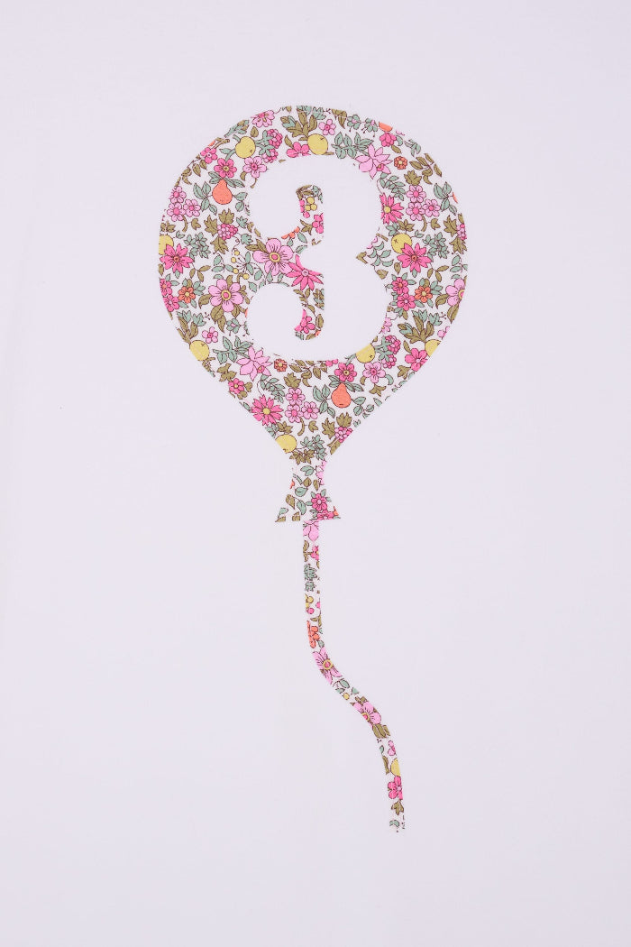 A close up of a 3rd birthday white t-shirt with a balloon and number 3 on it made from Liberty Floral print fabric.
