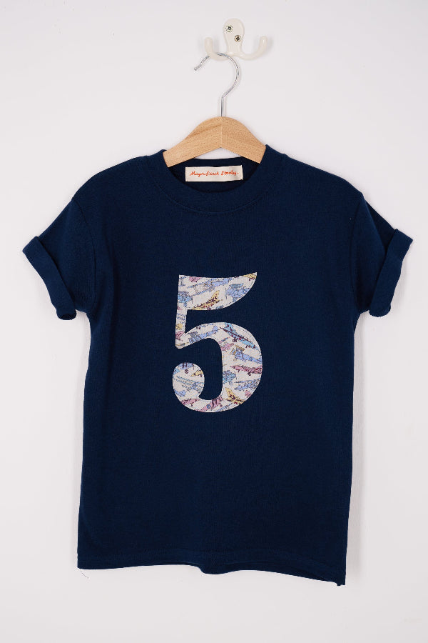a Magnificent Stanley kids Number kids cotton Navy T-Shirt in Tom's Jet Liberty Print hanging on a hanger