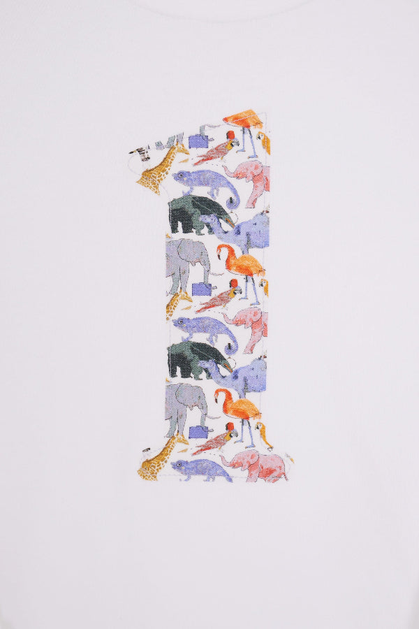 A first birthday wearing a white cotton t-shirt with a zoo animal number 1 on the front.