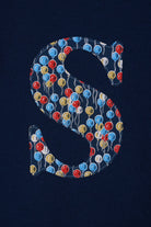 A close up of a navy cotton personalised t-shirt with an initial in Liberty balloon print.