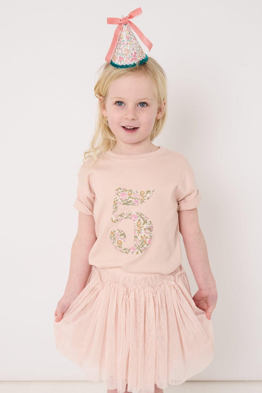 a five year old birthday girl wearing a pale pink t-shirt with the number 5 sewn on the front cut from liberty floral Mamie print.