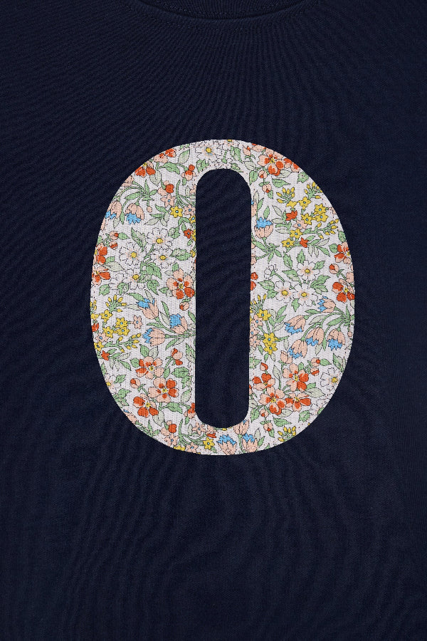 a personalised kids navy t-shirt with an initial cut from nazanin liberty floral print on the front.