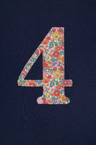 A close up of a navy cotton t-shirt with the number 4 sewn on the front cut from liberty floral Nell Annie and May print.