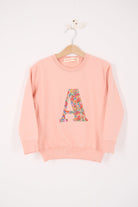 a personalised dusty pink sweatshirt with an initial on in floral Nell Annie and May Liberty print on the front. 