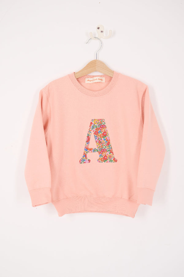 a personalised dusty pink sweatshirt with an initial on in floral Nell Annie and May Liberty print on the front. 