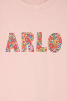 a pink t-shirt with her name on the front in Liberty Nell Annie May floral print.