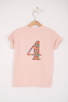 a pale pink t-shirt with a Liberty Nell Annie and May floral large number on the back