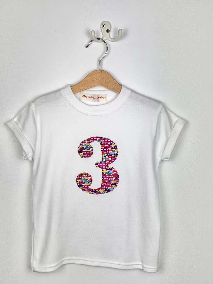 White t-shirt with colorful number '3' design on a hanger against a white background