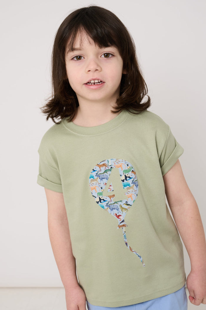 Child wearing a sage green t-shirt with a colourful number balloon design made from animal liberty print on a white background