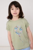 Child wearing a sage green t-shirt with a colourful number balloon design made from animal liberty print on a white background