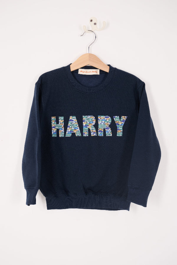 a navy sweatshirt with the name 'HARRY' sewn on it cut from Liberty print card fabric
