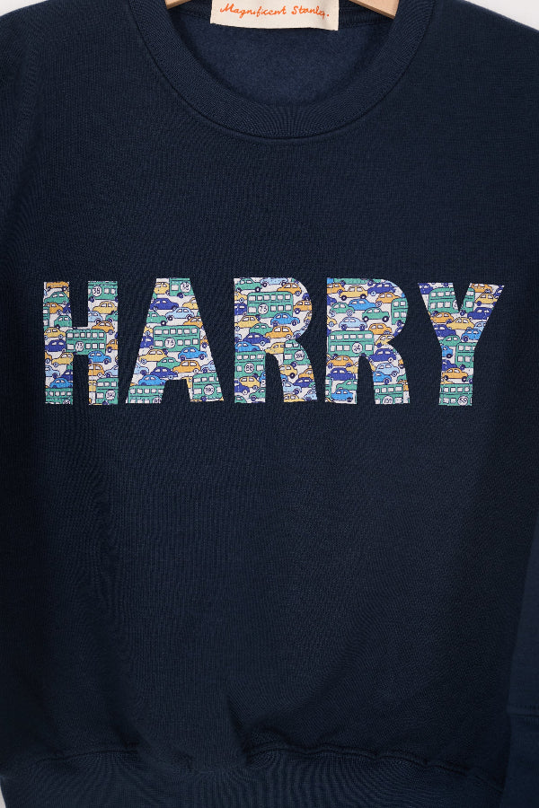 a navy sweatshirt with the name 'HARRY' sewn on it cut from Liberty print card fabric