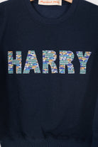a navy sweatshirt with the name 'HARRY' sewn on it cut from Liberty print card fabric