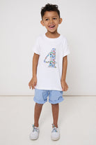 A 4 year old birthday boy wearing a white cotton t-shirt with the number 4 sewn on the front cut from liberty Quey 2 zoo animal print.