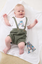 a smiling baby wearing a personalised baby bodysuit made from Liberty zoo animal print Quey 2 on a matching personalised blanket