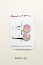 Pair of liberty sadie rose floral hair clips on a 'Magnificent Stanley' branded card.