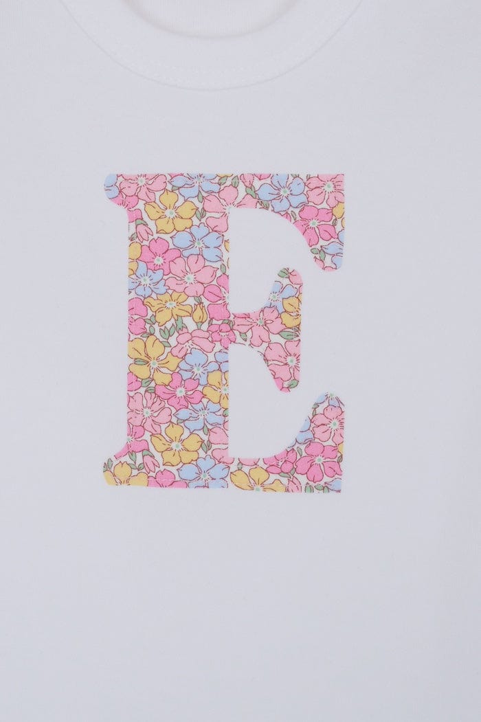a personalised bodysuit baby grow with an initial cut from floral sadie roseLiberty print. A close up of the appliqué stitching.