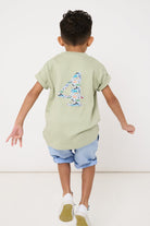 a 4 year old boy wearing a sage green t-shirt with a large number 4 on the front cut from zoo animal Liberty print