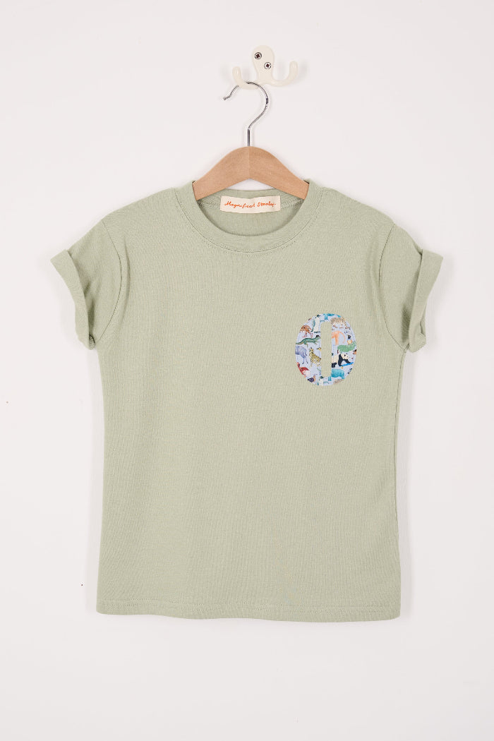 Green t-shirt with floral design on a hanger against a white background