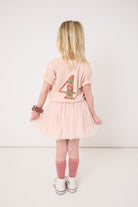 Child wearing a pink dress with number 4 design on a white background