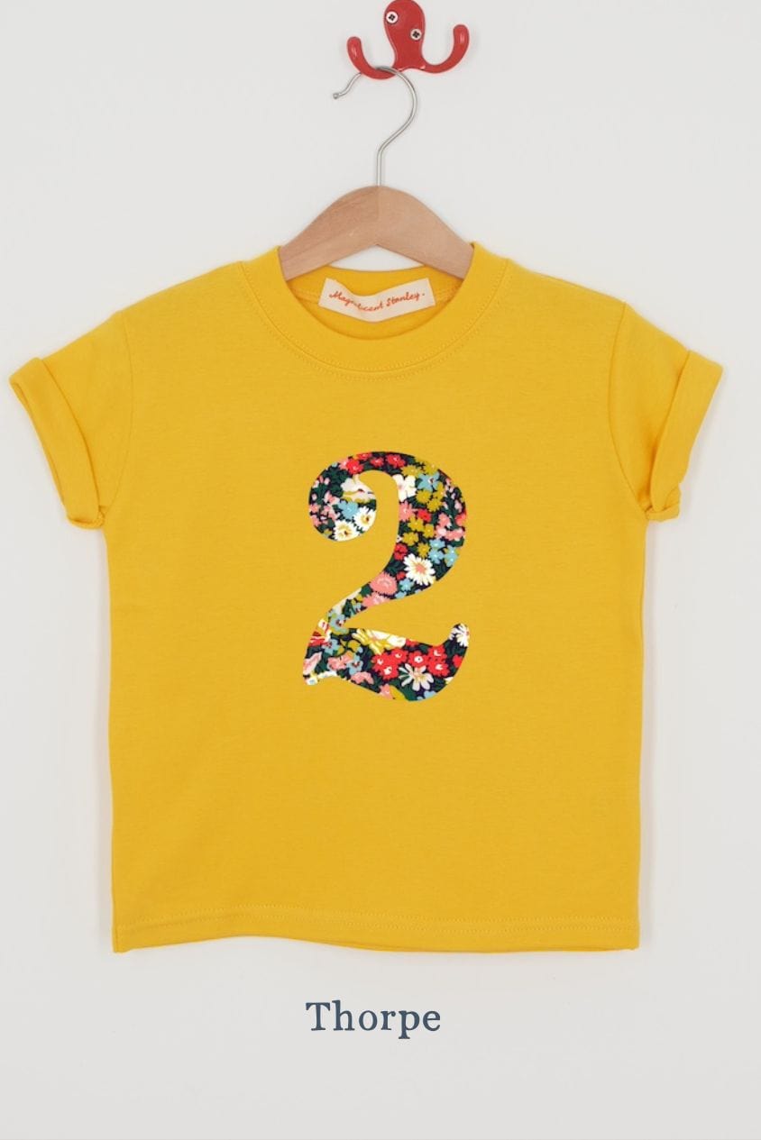a yellow birthday t-shirt with a number 2 cut from thorpe liberty floral print on the front.