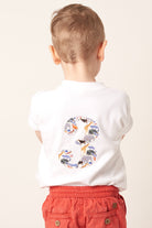 Child wearing a white t-shirt with a colourful number 3 design in zoo liberty print on the back.