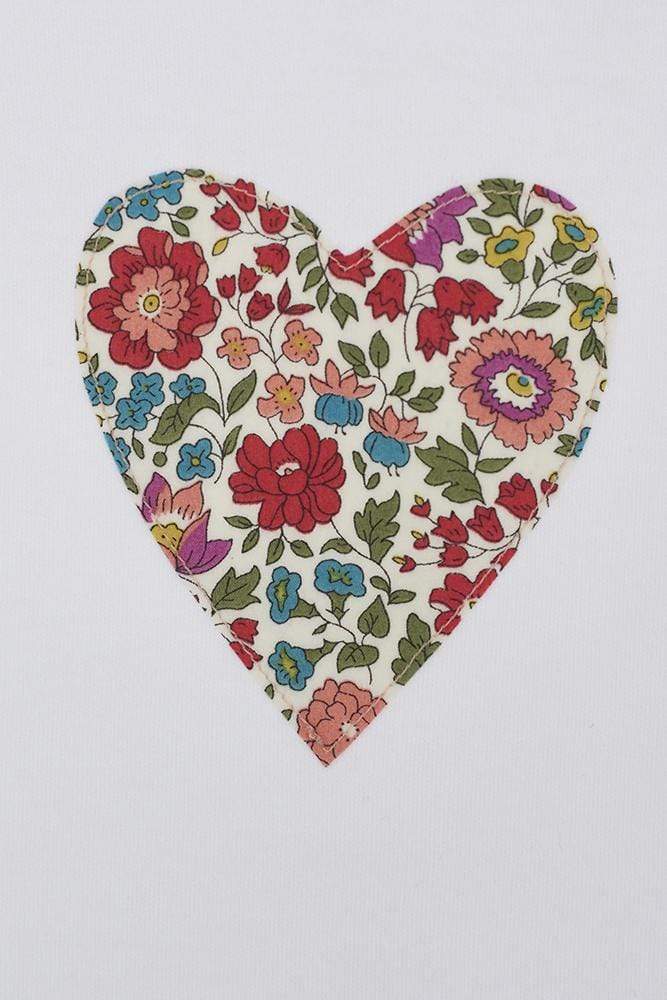 a bodysuit with a heart on made from d'anjo liberty print fabric. a close up of the appliqué stitching.