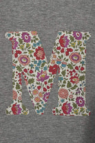 A personalised grey sweatshirt with an initial on in floral Liberty fabric.