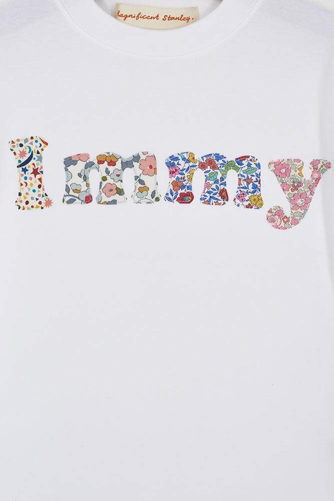 A close up of a personalised white t-shirt with her name on in a mix of Liberty prints.