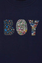 A close up of a  navy t-shirt with a name on in mixed Liberty fabrics.