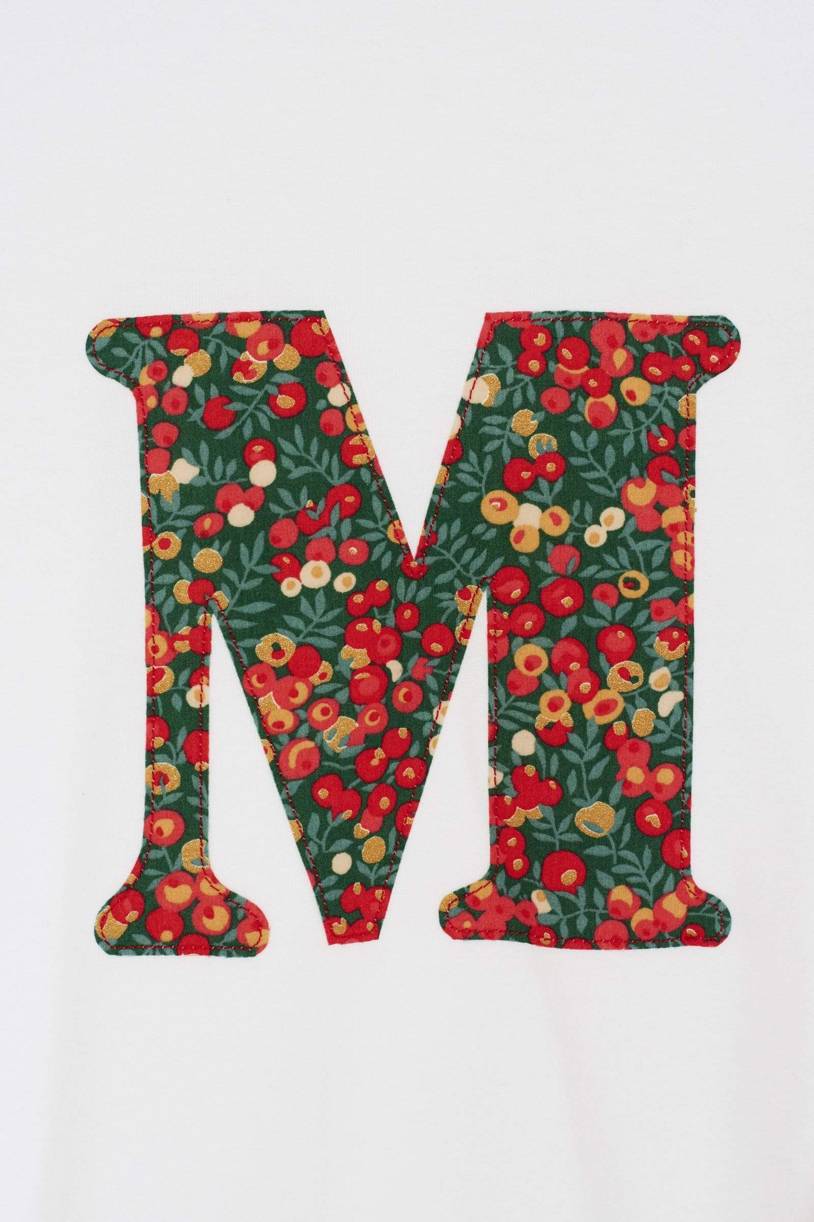 A personalised white t-shirt with a her initial on the front made from Liberty Glitter Wiltshire berry fabric.